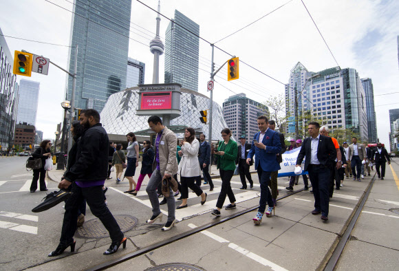 29일(현지시간) 캐나다 토론토에서 ‘2019 여성 신발 신고 1마일 걷기’ 행사가 열린 가운데 남성 참가자들이 하이힐을 신은채 걷고 있다. 신화 연합뉴스