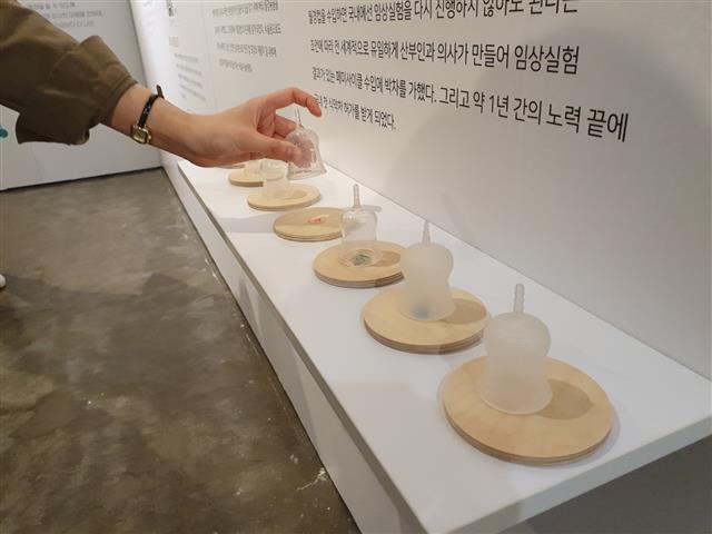 지난달 25~26일 소셜벤처 이지앤모어가 주최해 서울 성동구에서 열린 제2회 월경 박람회에서 한 방문객이 직접 생리컵을 만져 보며 여러 제품을 비교하고 있다.