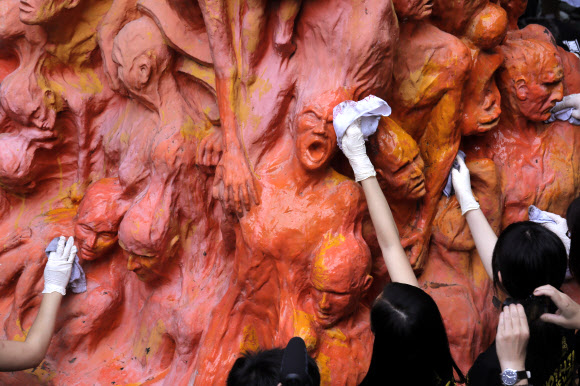 4일(현지시간) 홍콩 대학에서 대학생들이 1989년 ‘톈안먼 사태’로 희생된 사람들의 추모비인 ‘수치의 기둥’ 동상을 청소하고 있다. AP 연합뉴스