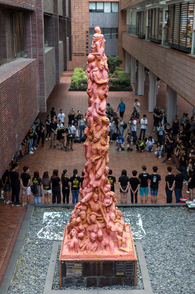 4일(현지시간) 홍콩 대학에서 대학생들이 1989년 ‘톈안먼 사태’로 희생된 사람들의 추모비인 ‘수치의 기둥’ 동상 옆에서 묵념하고 있다. EPA 연합뉴스