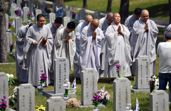 현충일을 하루앞둔 5일 서울 현충원을 찾은 승려들이 묘비 앞에서 기도를 하고 있다.  2019.6.5 박지환기자 popocar@seoul.co.kr