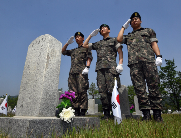 현충일을 하루앞둔 5일 서울 현충원을 찾은 3사단 백골부대원들이 한국전쟁당시 전사한 선배부대원의 묘비를 찾아 경례를 하고 있다. 2019.6.5 박지환기자 popocar@seoul.co.kr