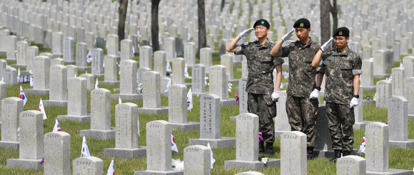 현충일을 하루앞둔 5일 서울 현충원을 찾은 3사단 백골부대원들이 한국전쟁당시 전사한 선배부대원의 묘비를 찾아 경례를 하고 있다. 2019.6.5 박지환기자 popocar@seoul.co.kr