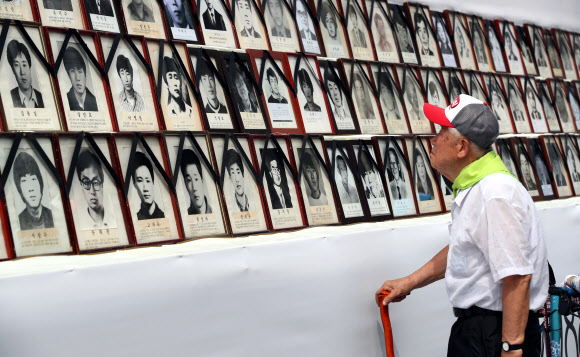 8일 오후 서울 청계광장에서 열린 28회 민족민주열사·희생자 범국민추모제에서 한 시민이 고인의 영정을 살펴보고 있다. 2019.6.8  연합뉴스