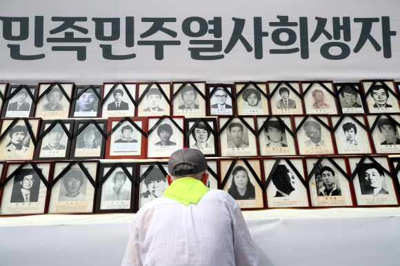 8일 오후 서울 청계광장에서 열린 28회 민족민주열사·희생자 범국민추모제에서 한 시민이 고인의 영정을 살펴보고 있다. 2019.6.8  연합뉴스