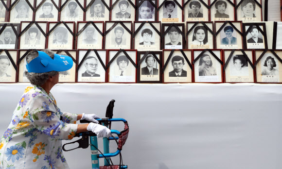 8일 오후 서울 청계광장에서 열린 28회 민족민주열사·희생자 범국민추모제에서 한 시민이 고인의 영정을 살펴보고 있다. 2019.6.8  연합뉴스