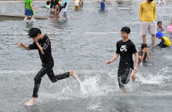 초여름 날씨를 보인 9일 오후 서울 여의도 달빛분수를 찾은 학생들이 더위를 식히고 있다. 2019.6.9. 도준석 기자 pado@seoul.co.kr