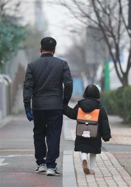 한 학부모가 아이 손을 잡고 유치원에 가고 있는 모습.  연합뉴스