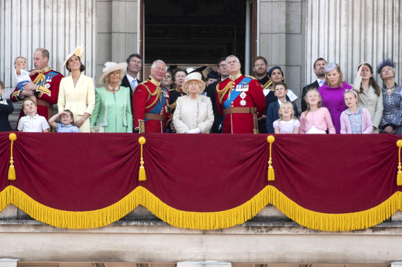 엘리자베스 2세 영국 여왕의 생일 축하 행사가 열린 8일(현지시간) 왕실 가족들이 런던 버킹엄궁 인근에서 근위기병대의 군기분열식을 지켜보고 있다. 앞줄 왼쪽부터 윌리엄 왕세손 및 미들턴 왕세손빈 부부와 세 자녀, 카밀라 왕세자빈과 찰스 왕세자 부부, 여왕, 앤드루 왕자, 앤드루 왕자 오른쪽 옆 뒤편에 해리 왕자와 마클 왕자비 부부.  런던 AP 연합뉴스