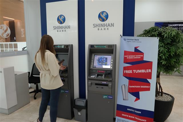 지난달 10일 인도네시아 자카르타에 있는 신한인도네시아은행 본점을 찾는 한 고객이 현금인출기(ATM)를 이용하고 있다. 인도네시아 국민들은 ATM을 송금, 출금뿐 아니라 간편결제를 위한 충전에도 활용한다.