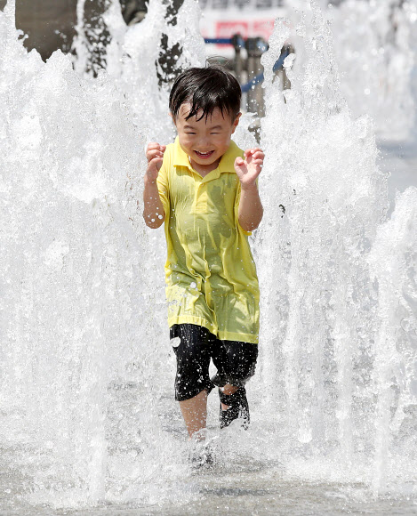 맑고 쾌청한 날씨를 보이는 16일 오후 서울 광화문광장 바닥분수대에서 한 어린이가 물놀이를 하고 있다. 2019.6.16  연합뉴스