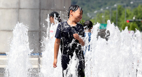맑고 쾌청한 날씨를 보이는 16일 오후 서울 광화문광장 바닥분수대에서 한 어린이가 물놀이를 하고 있다. 2019.6.16  연합뉴스