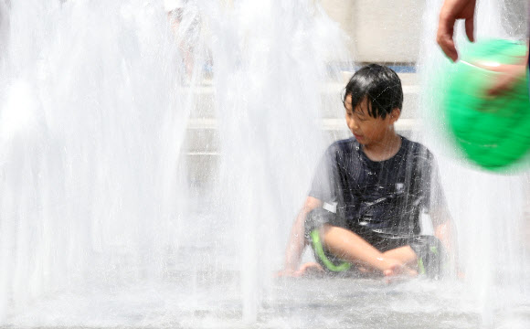 맑고 쾌청한 날씨를 보이는 16일 오후 서울 광화문광장 바닥분수대에서 한 어린이가 물놀이를 하고 있다. 2019.6.16  연합뉴스