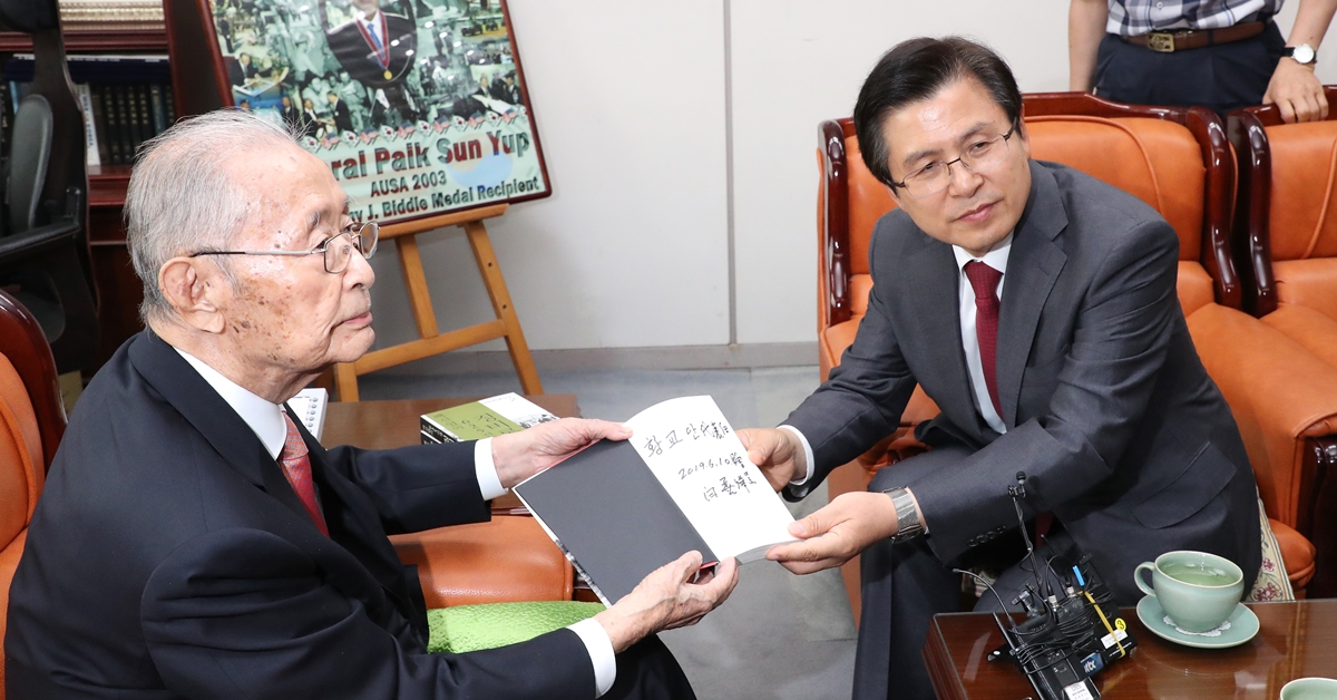 황교안(오른쪽) 자유한국당 대표가 지난 10일 오후 서울 용산 전쟁기념관 군사 편찬연구 자문위원장실에서백선엽 장군(예비역 대장)을 예방해 백 장군의 저서 ‘징비록’을 선물 받고 있다. 2019.6.10 연합뉴스