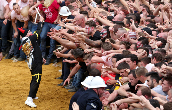 유네스코가 지정한 구전무형문화유산 ‘두카스(두두) 축제’ 참가자들이 16일(현지시간) 벨기에 몬스에서 열린 ‘선’을 대표하는 성 조지와 ‘악’을 대표하는 용 사이의 ‘루마콘’ 싸움에 참여하고 있다. 참가자들은 용꼬리에 붙은 털을 잡기 위해 몰려든다. 로이터 연합뉴스