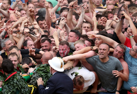 유네스코가 지정한 구전무형문화유산 ‘두카스(두두) 축제’ 참가자들이 16일(현지시간) 벨기에 몬스에서 열린 ‘선’을 대표하는 성 조지와 ‘악’을 대표하는 용 사이의 ‘루마콘’ 싸움에 참여하고 있다. 참가자들은 용꼬리에 붙은 털을 잡기 위해 몰려든다. 로이터 연합뉴스