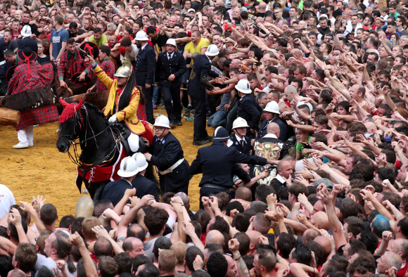 유네스코가 지정한 구전무형문화유산 ‘두카스(두두) 축제’ 참가자들이 16일(현지시간) 벨기에 몬스에서 열린 ‘선’을 대표하는 성 조지와 ‘악’을 대표하는 용 사이의 ‘루마콘’ 싸움에 참여하고 있다. 참가자들은 용꼬리에 붙은 털을 잡기 위해 몰려든다. 로이터 연합뉴스