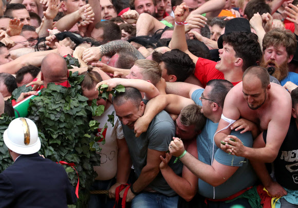 유네스코가 지정한 구전무형문화유산 ‘두카스(두두) 축제’ 참가자들이 16일(현지시간) 벨기에 몬스에서 열린 ‘선’을 대표하는 성 조지와 ‘악’을 대표하는 용 사이의 ‘루마콘’ 싸움에 참여하고 있다. 참가자들은 용꼬리에 붙은 털을 잡기 위해 몰려든다. 로이터 연합뉴스