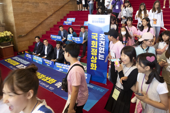 17일 오전 국회 견학을 마친 어린이들이 로텐더홀 계단에서 국회정상화를 촉구하는 을지로위원회 위원들 앞을 지나고 있다. 2019.6.17 연합뉴스