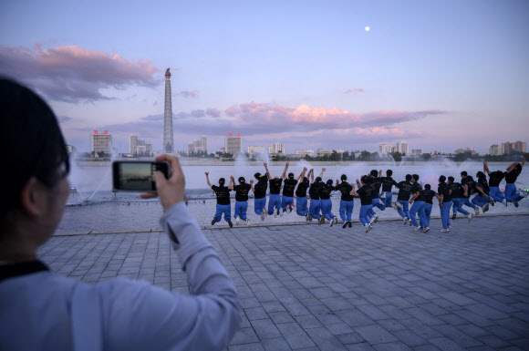 15일 북한 평양을 방문한 관광객들이 주체사상탑을 배경으로 기념 사진을 찍고 있다. AFP 연합뉴스