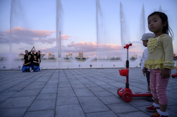 15일 북한 평양을 방문한 관광객들이 주체사상탑을 배경으로 기념 사진을 찍고 있다. AFP 연합뉴스