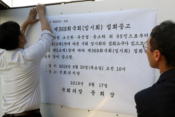 국회 의사과 직원들이 17일 국회 정문 앞 게시판에 ‘제369회 6월 국회(임시회)집회요구서’를 붙이고 있다. 바른미래당, 민주평화당, 정의당 등 3당은 이날 6월 임시국회 소집요구서를 냈다. 일부 더불어민주당과 무소속 의원들도 서명했다. 연합뉴스