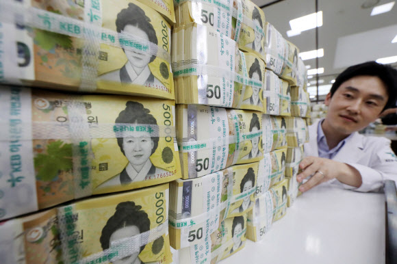 한국은행이 2009년 6월 23일 새로운 최고 액면 은행권 5만 원권을 발행한 지 올해로 10주년이 됐다. 이후 5만 원권이 중심 권종으로 자리 잡게 되면서 초기 문제로 지적됐던 색상 혼돈, 위폐 우려, 낮은 환수율 문제는 대부분 해소된 것으로 나타났다. 19일 서울 KEB하나은행에서 직원이 오만원권을 들어보이고 있다.  2019.6.19  연합뉴스