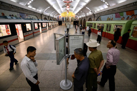 평양 시민들이 19일(현지시간) 지하철역 신문 가판대 신문을 읽고 있다. AFP 연합뉴스