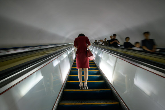 평양 시민이 19일(현지시간) 지하철역 엘리베이터에서 휴대폰을 보고 있다. AFP 연합뉴스