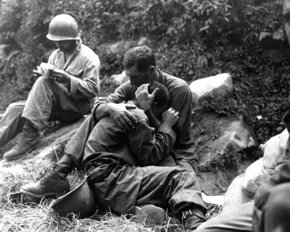 1950년 8월 28일 낙동강 전선에서 죽은 전우를 애도하며 서로 어깨를 감싼 채 흐느끼는 미군 병사들. 옆에서 의무병이 사상자 목록을 작성하고 있다. 문예출판사 제공