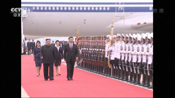 중국 최고지도자로는 14년 만에 방북한 시진핑(앞줄 오른쪽) 중국 국가주석이 20일 평양 순안공항에 도착해 김정은 북한 국무위원장과 함께 의장대를 사열하고 있다. 두 정상 뒤로는 부인 펑리위안(뒷줄 오른쪽) 여사와 리설주 여사가 걸어가고 있다. CCTV 캡처