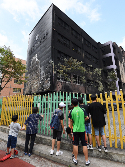 27일 오전 서울 은평구 응암동 소재 은명초등학교에서 은명초 재학생들이 지난 26일 발생한 화재로 인해 검게 그을린 학교를 바라보고 있다. 2019.6.27  오장환 기자 5zzang@seoul.co.kr