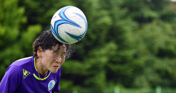 유정규(64)선수가 우중경기 중 헤딩을 하고 있다. 2019. 6. 27 정연호 기자 tpgod@seoul.co.kr