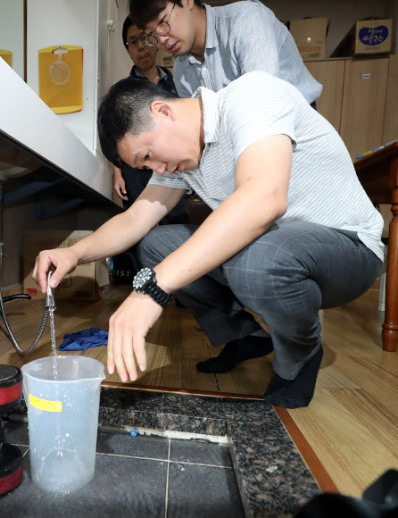 27일 오전 인천시 서구 청라동 A아파트 관리사무소 화장실에서 공유훈 한국환경공단 상수도청 과장이 수돗물 수질을 검사할 시료를 채취하고 있다. 해당 수돗물의 탁도는 기준치(0.5NTU)를 밑도는 0.3NTU로 나왔다. 2019.6.27  연합뉴스