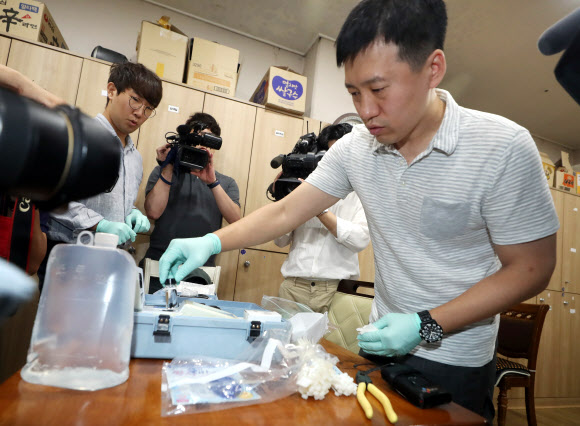 27일 오전 인천시 서구 청라동 A아파트 관리사무소 화장실에서 공유훈 한국환경공단 상수도청 과장이 수돗물 시료를 채취해 탁도를 측정하고 있다. 해당 수돗물의 탁도는 기준치(0.5NTU)를 밑도는 0.3NTU로 나왔다. 2019.6.27  연합뉴스