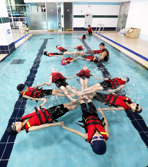 27일 오전 경기도 수원시 장안구민회관 수영장에서 초등학교 4학년 학생들이 본격적인 여름 휴가철을 앞두고 생존수영을 배우고 있다. 2019.6.27  연합뉴스