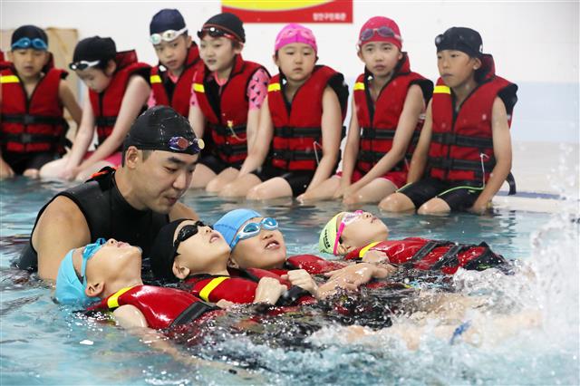 27일 오전 경기도 수원시 장안구 수원도시공사 장안구민회관에서 초등학생들이 여름 휴가철을 앞두고 생존 수영을 배우고 있다.  생존수영은 잎새뜨기, 체온유지법 등으로 구조될 때까지 견디는 물놀이 안전사고 예방법이다. 2019.6.27 뉴스1