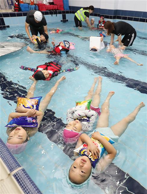 27일 오전 대구 달서구 송현동 문화유치원 수영장에서 유치원생들이 구명조끼를 비롯해 과자봉지, 페트병, 스티로폼 등 주변의 도구를 이용한 생존수영을 배우고 있다. 대구시교육청은 2019학년도 유아 물놀이 안전사고 예방을 위해 지난 4월부터 유아 생존수영 교육을 시행하고 있다. 유아 생존수영은 일반적인 기능 위주의 수영이 아니라 물에 대한 적응력 향상과 비상시 구조자가 올 때까지 주변의 도구 등을 이용해 물에서 버틸 수 있는 능력을 배우게 된다. 2019.6.27 뉴스1