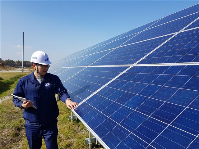 LS산전 관계자가 28㎿급 일본 치토세 태양광 발전소 모듈을 점검하는 모습. LS산전 제공