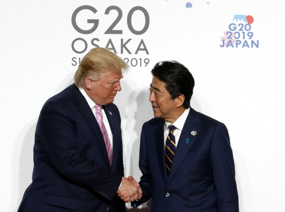 도널드 트럼프(왼쪽) 미국 대통령이 28일 오전 일본 오사카에서 열린 주요 20개국(G20) 정상회의 공식환영식에서 의장국인 일본 아베 신조 총리와 악수하고 있다. 오사카 AP 연합뉴스