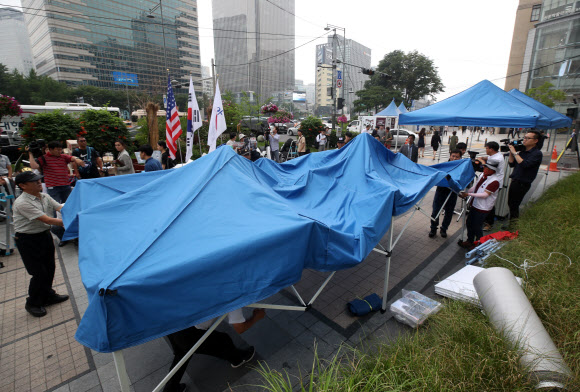 우리공화당(구 대한애국당) 당원들이 28일 오후 광화문광장에 설치한 천막을 청계광장 일대로 이동 설치하고 있다. 2019.6.28  연합뉴스
