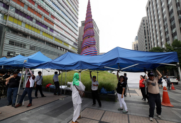 우리공화당(구 대한애국당) 당원들이 28일 오후 광화문광장에 설치한 천막을 청계광장 일대로 이동 설치하고 있다. 2019.6.28  연합뉴스