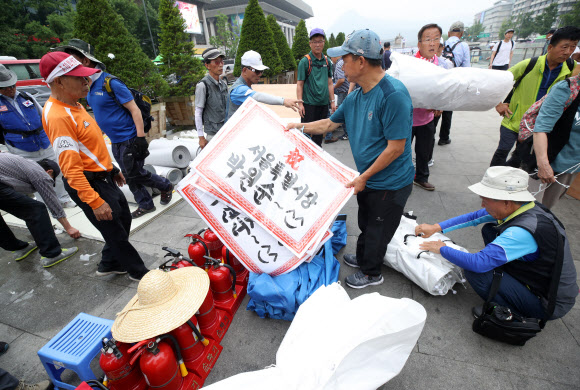 우리공화당(구 대한애국당) 당원들이 28일 오전 광화문광장에 설치한 천막을 청계광장 일대로 옮기고 있다. 2019.6.28  연합뉴스