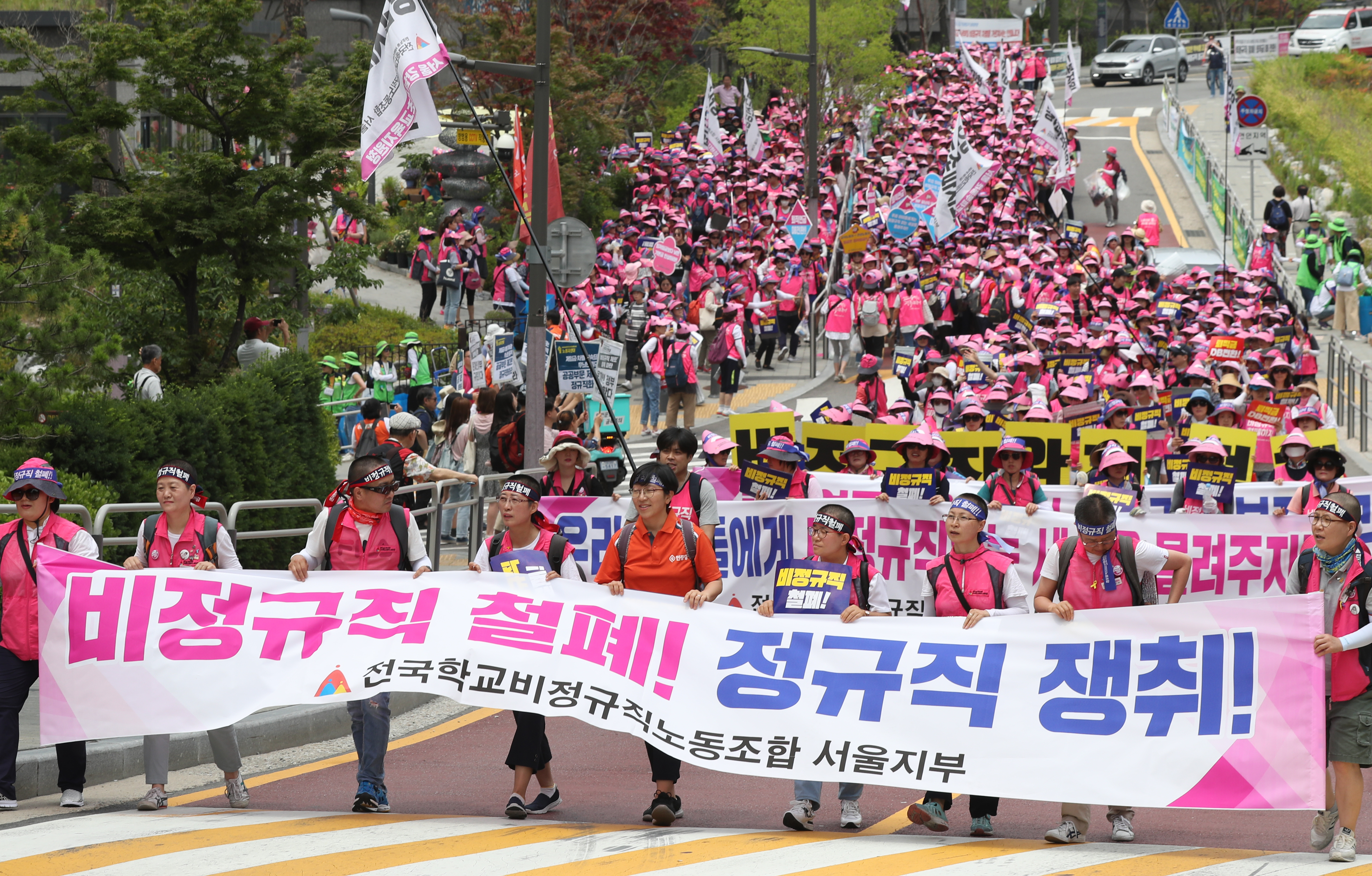 전국학교비정규직연대회의(연대회의) 조합원들이 3일 오전 서울 종로구 서울시교육청 앞에서 총파업 출정식을 마친 뒤 광화문광장을 향해 행진하고 있다. 연대회의는 이날 출정식에서 학교 비정규직의 정규직화를 비롯해 비정규직과 정규직 간 임금 격차 해소, 최저임금 인상 등을 요구했다. 2019.7.3 뉴스1