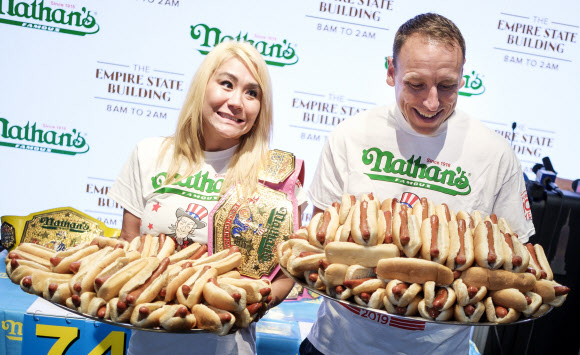 네이선의 ‘7월 국제 핫도그 먹기 대회’의 각 부문에서 압도적인 챔피언인 미키 스도(왼쪽)와 조이 체스트넛(오른쪽)이 3일(현지시간) 미국 뉴욕 코니 아일랜드에서 열린 올해 대회에 앞서, 그들이 지난해 먹은 핫도그가 담긴 접시를 들고 포즈를 취하고 있다. 이 연례 행사는 1916년에 처음 시작됐고 우승자는 2만 달러를 받게 된다. EPA 연합뉴스