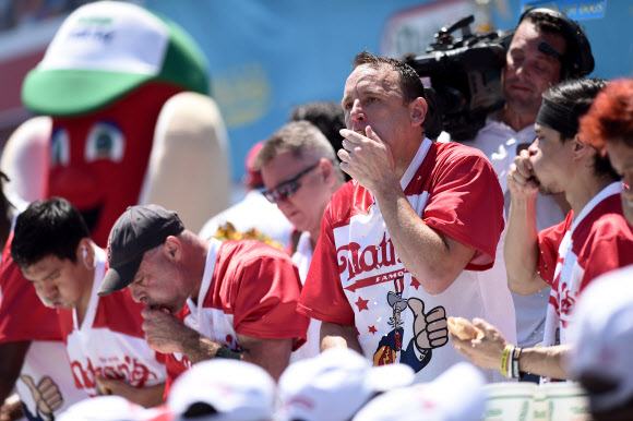 미국의 독립기념일인 4일(현지시간) 뉴욕 코니아일랜드에서 열린 103회 네이선스 핫도그 먹기 경연대회에서 우승한 조이 체스넛(오른쪽 2번째) 2019.7.5 UPI 연합뉴스