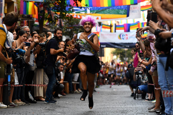 4일(현지시간) 스페인 마드리드 성소수자(LGBT) 커뮤니티에 인기 있는 지역인 추에카(Chueca)에서 ‘프라이드 하이힐 신고 달리기’가 열려 참가자가 힐을 신고 달리고 있다. AFP 연합뉴스