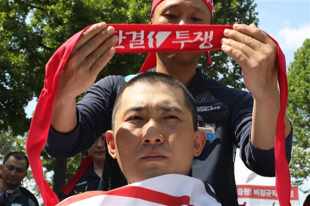 전국집배노동조합원들이 6일 오후 청와대 사랑채 앞에서 열린 우정노동자 총파업 결의대회에서 토요택배 폐지와 정규인력 증원 등을 촉구하며 삭발식을 하고 있다.2019.7.6 뉴스1