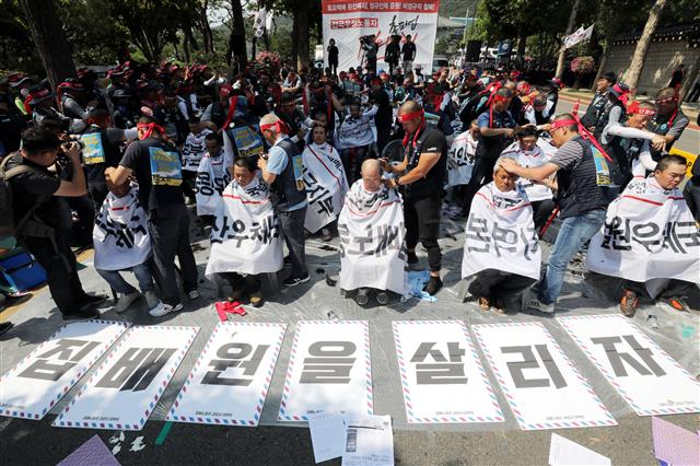 전국집배노동조합원들이 6일 오후 청와대 사랑채 앞에서 열린 우정노동자 총파업 결의대회에서 토요택배 폐지와 정규인력 증원 등을 촉구하며 삭발식을 하고 있다.2019.7.6 뉴스1