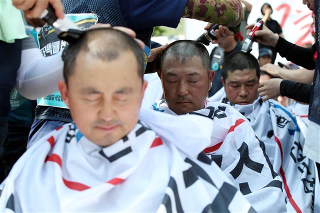 전국집배노동조합원들이 6일 오후 청와대 사랑채 앞에서 열린 우정노동자 총파업 결의대회에서 토요택배 폐지와 정규인력 증원 등을 촉구하며 삭발식을 하고 있다.2019.7.6 뉴스1